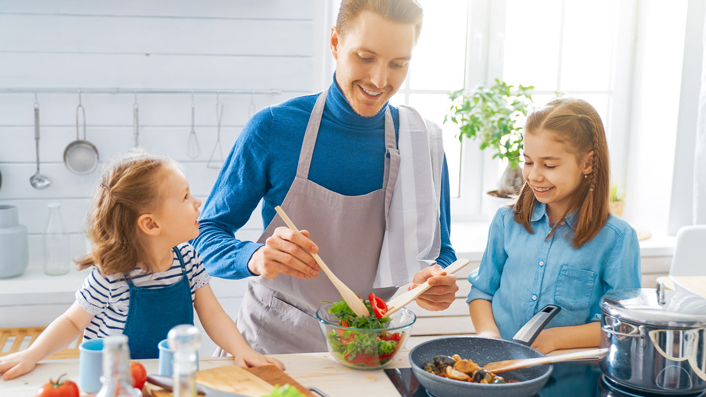 Šeima virtuvėje ruošia sveiką patiekalą.