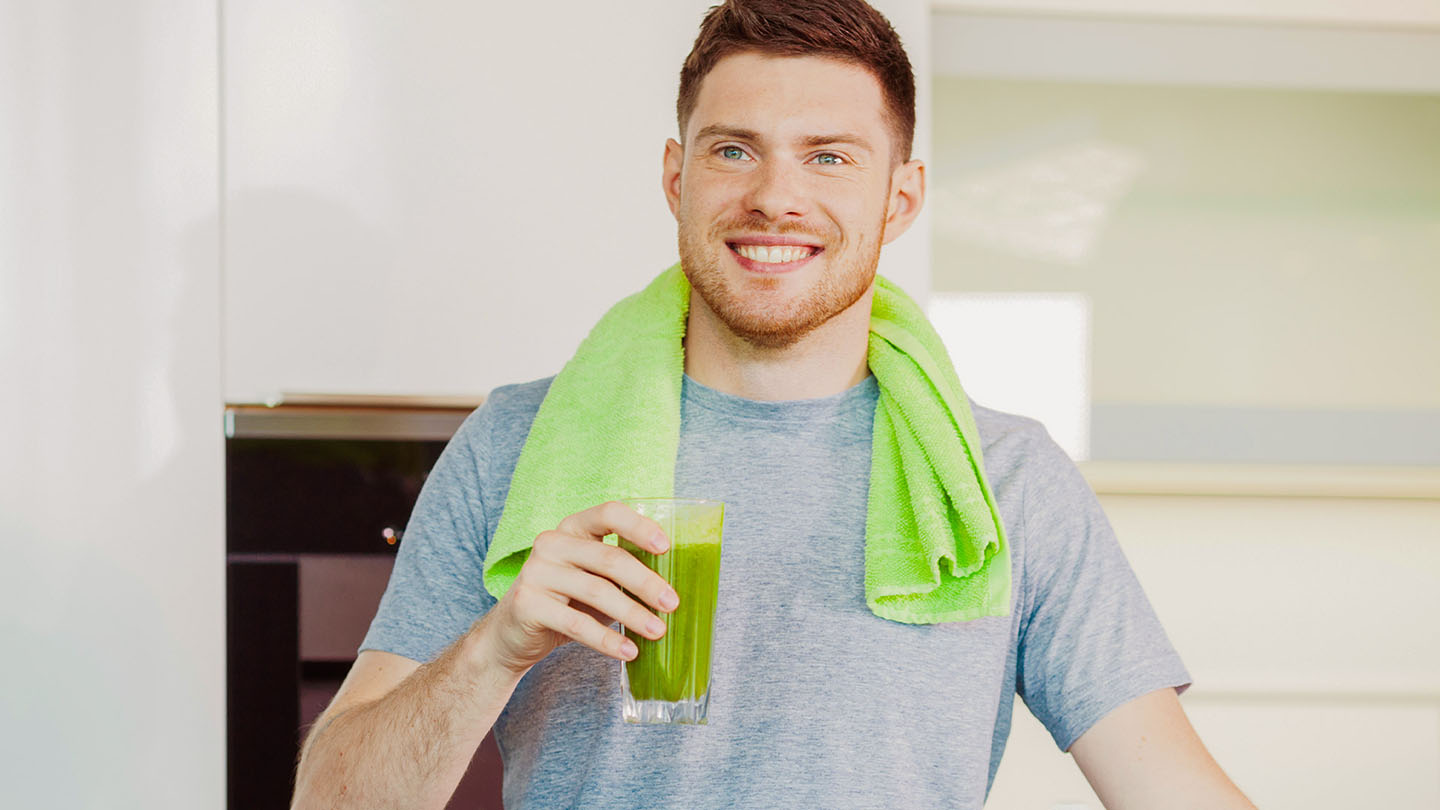 Vyras mėgaujasi sveiku žaliuoju kokteiliu.