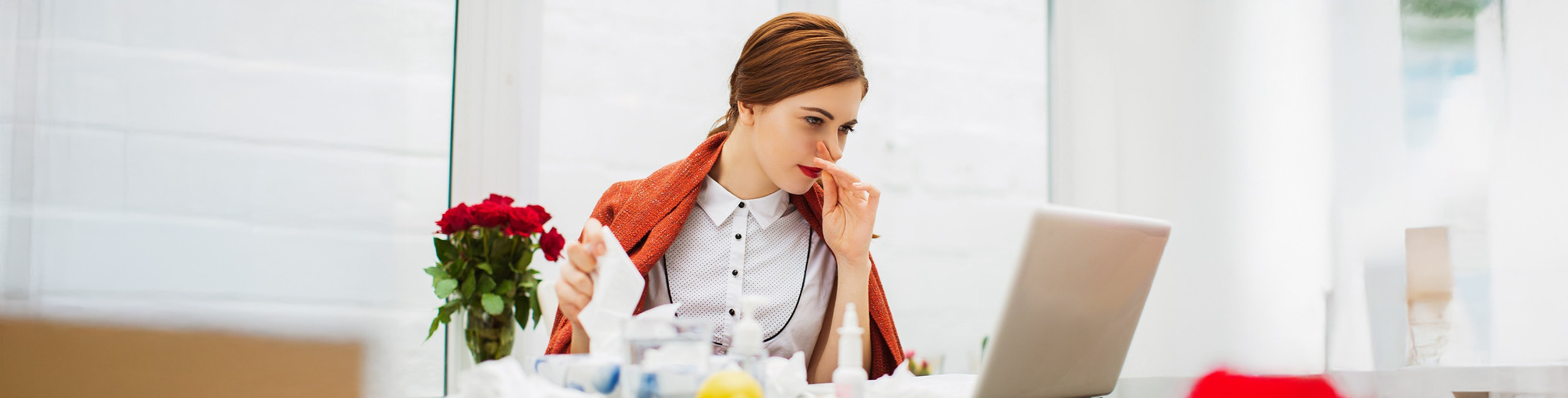 Serganti peršalusi moteris biure.