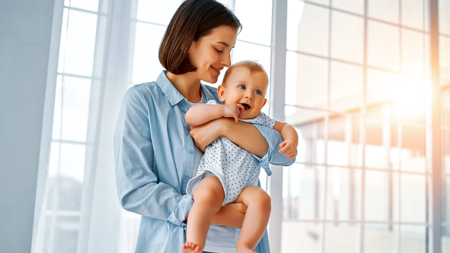 Motina su vaiku ant rankų.