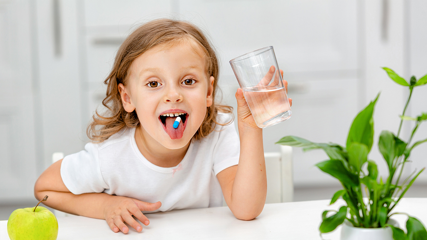 Jauna moksleivė vartoja maisto papildus imunitetui stiprinti.