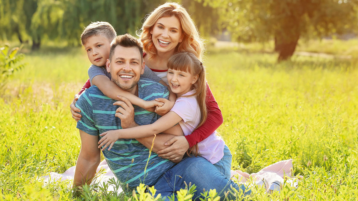 Laiminga šeima piknike gamtoje.