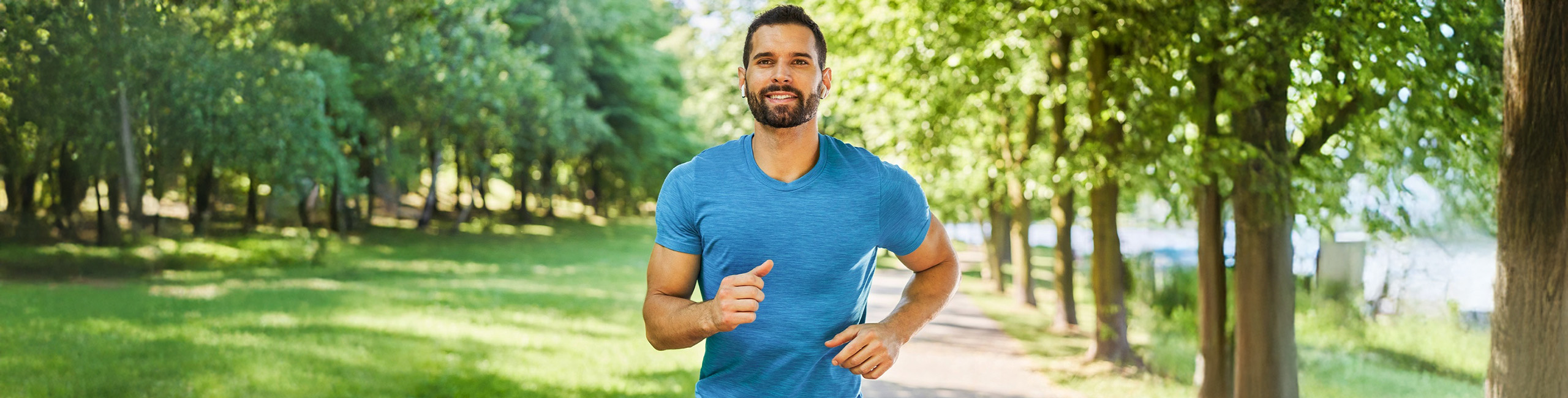 Vyras bėgioja parke, atlieka fizinį aktyvumą.