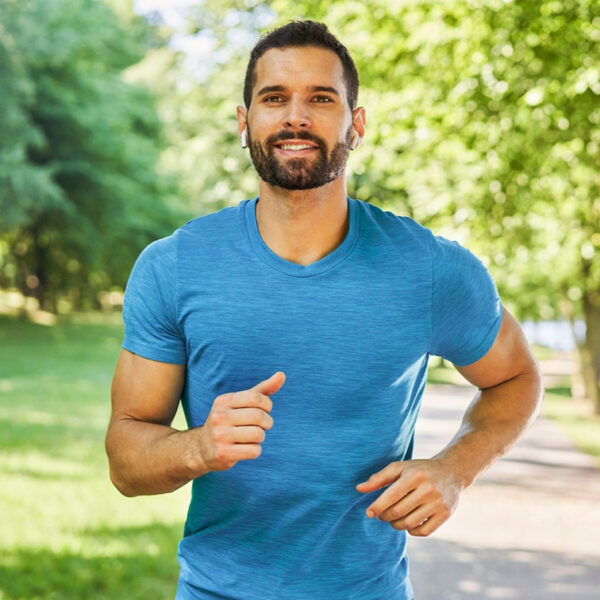 Vyras bėgioja parke, atlieka fizinį aktyvumą.